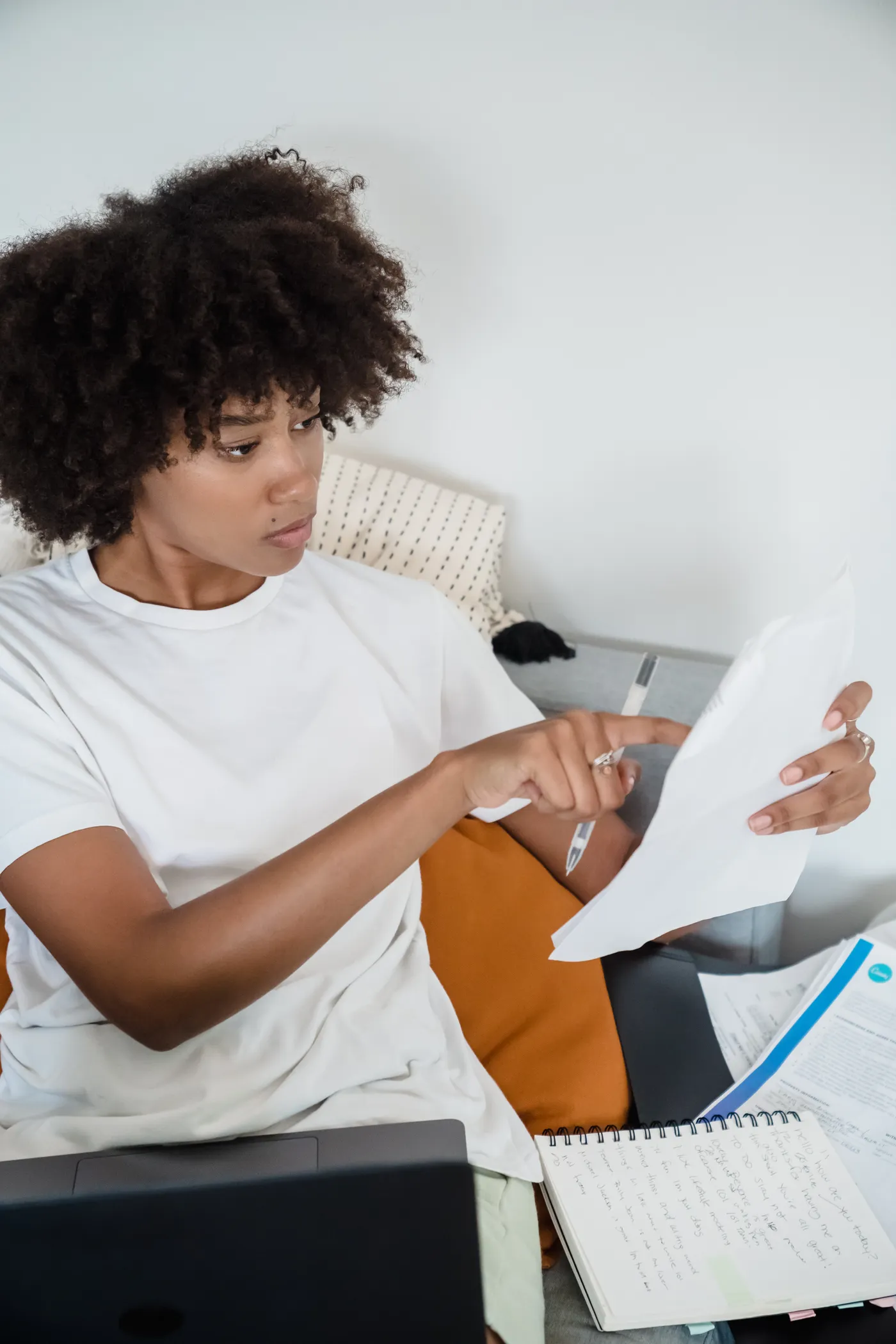 Woman reviewing household income and benefit documents beside a computer