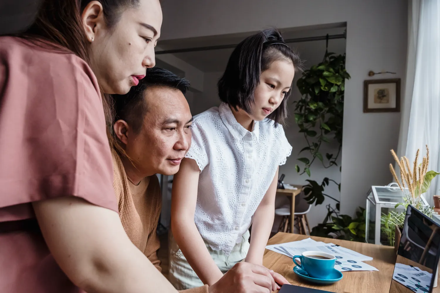 Family using a computer together at home while researching low-income technology help